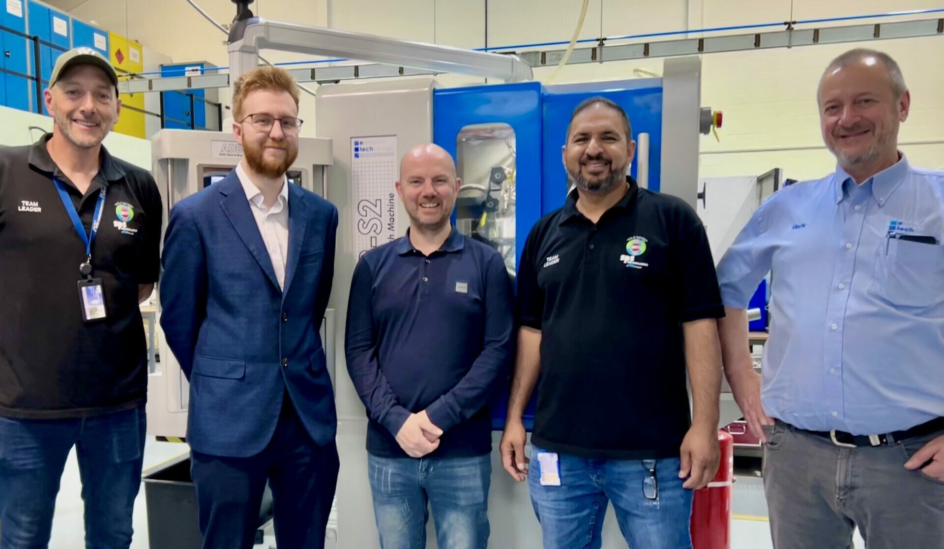 Engineers stood in front of their new machine